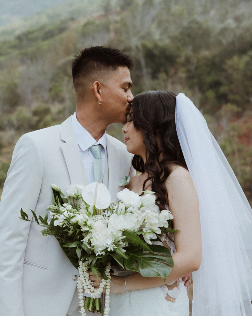 picture of the groom kissing the bride on the forehead