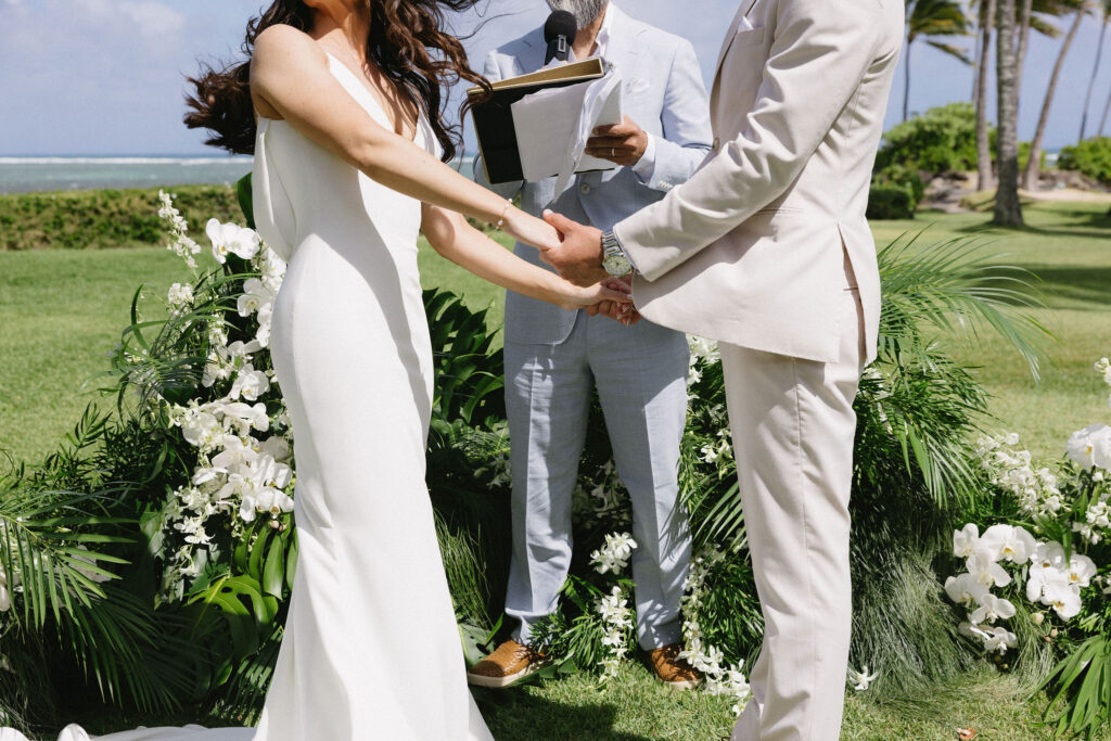 cute picture of the bride and groom holding hands during their ceremony
