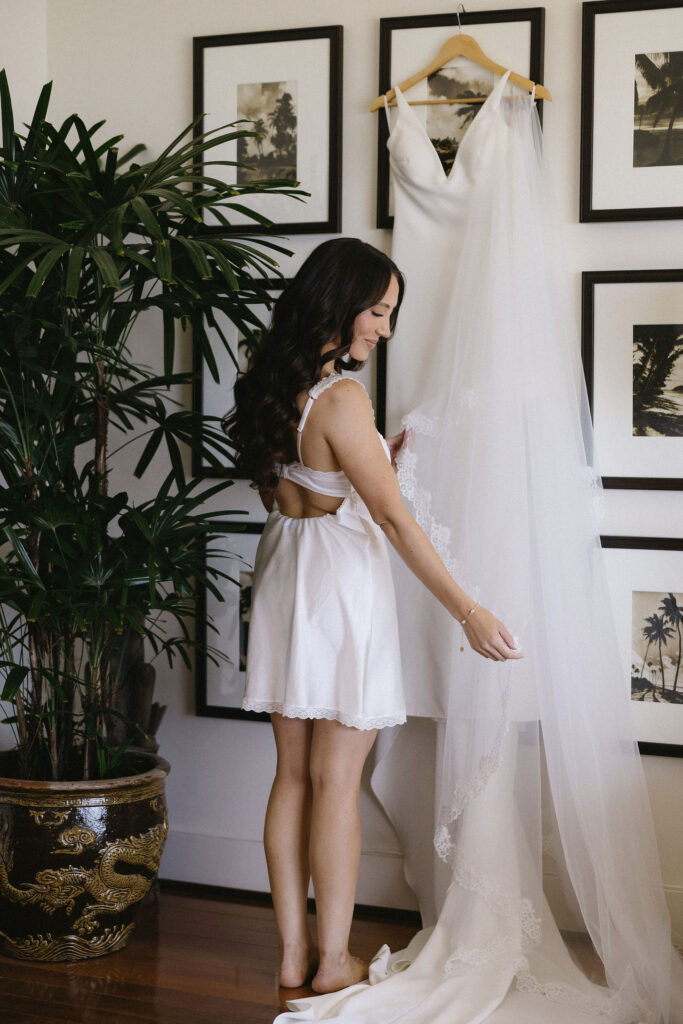 beautiful picture of the bride next to her wedding dress